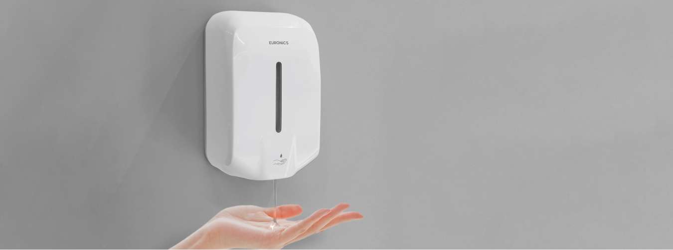 Image of Wall-mounted automatic soap dispenser dispensing liquid soap into hand for hygiene