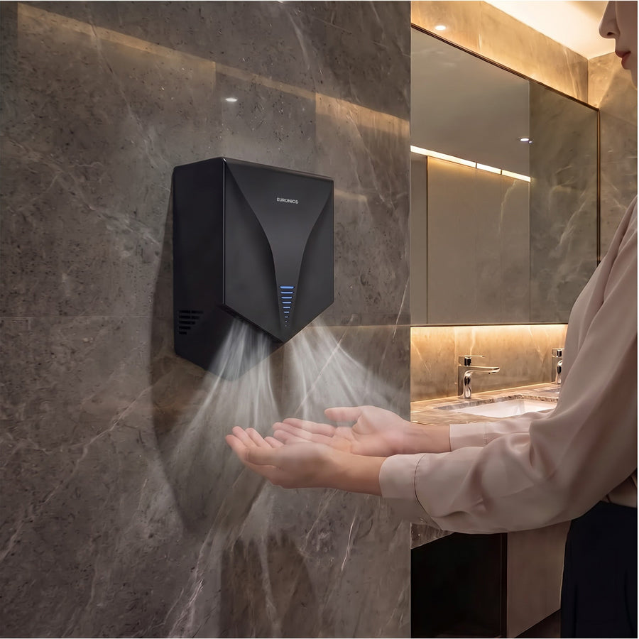 Image of Person drying hands with a black Euronics Industries PHD501 wall-mounted hand dryer in a bathroom.