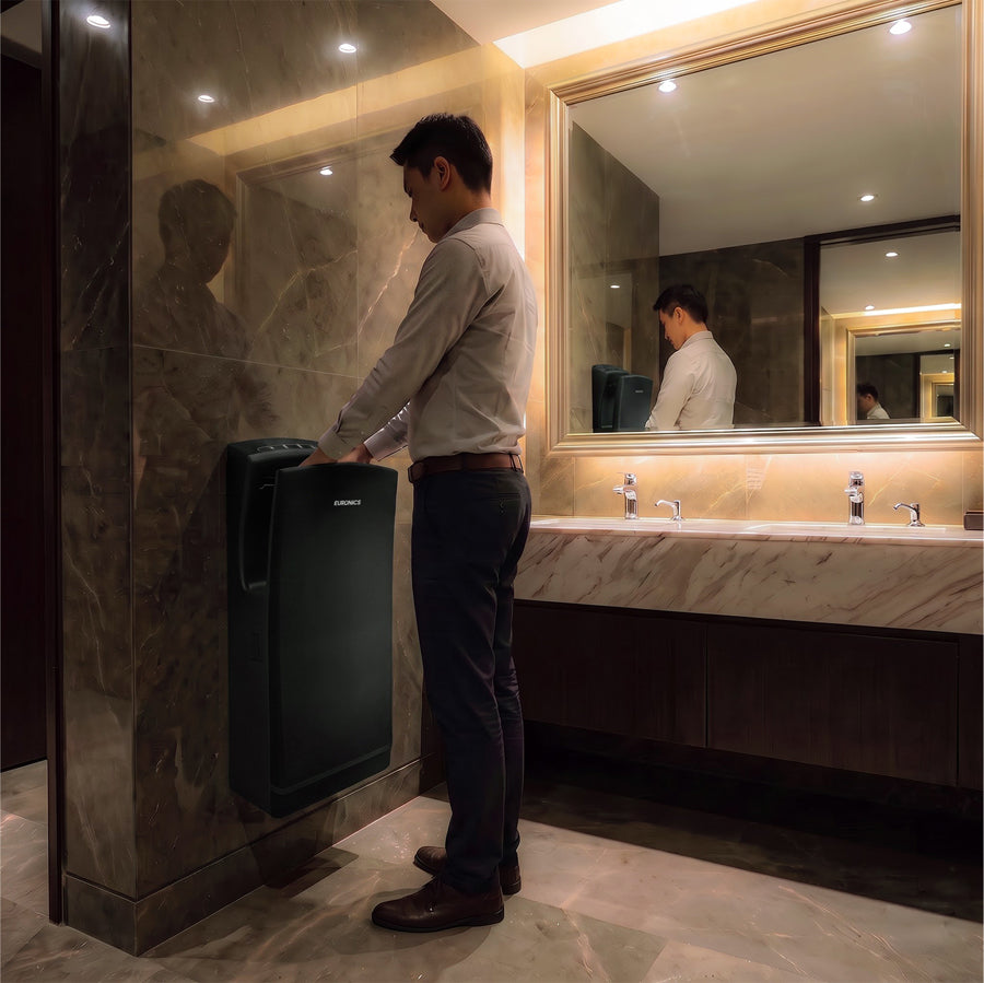 Image of A man using a Euronics Industries stainless steel hand dryer in a luxury marble washroom.