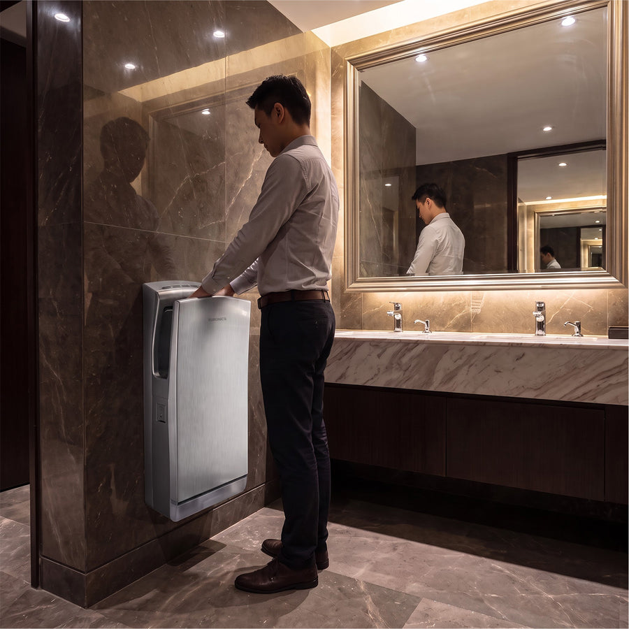 Man using Euronics Industries stainless steel hand dryer in a luxury marble washroom