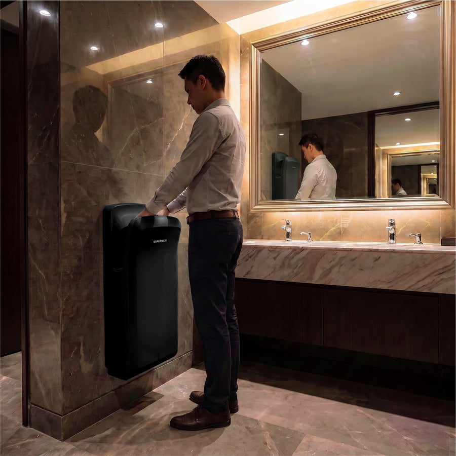 Image of A man using a Euronics Industries high-traffic ABS hand dryer in a luxury marble washroom.